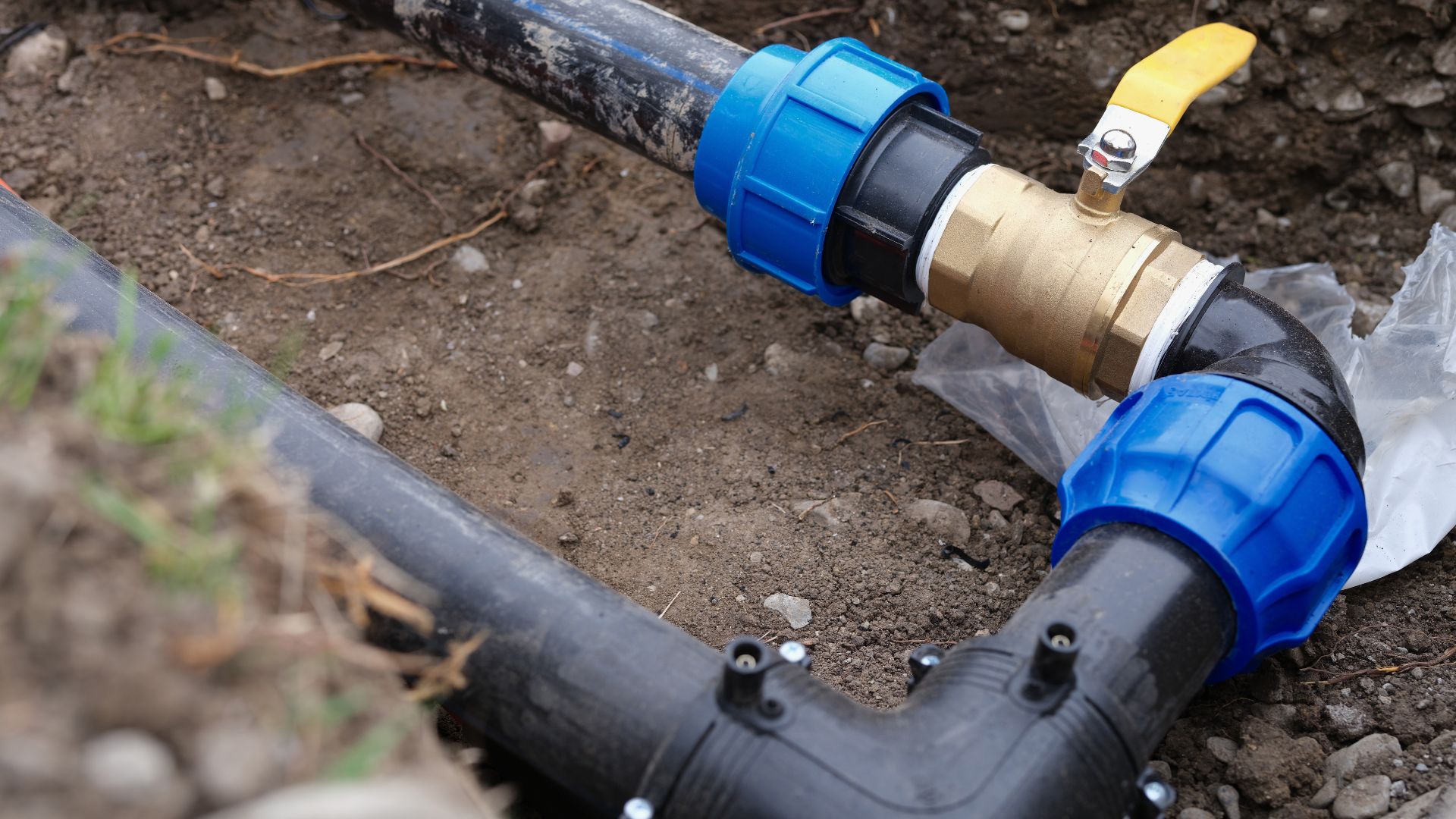 A pipe laying on the ground next to a plastic bag